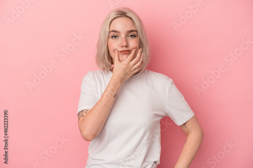 Young caucasian woman isolated on pink background doubting between two options.