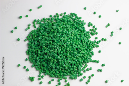 Green granules of polypropylene or polyamide on a white background. Plastics and polymers industry. Copy space. photo