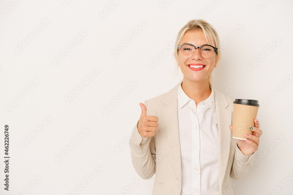 Young business Russian woman holding take away coffee isolated on white background smiling and raising thumb up Young business Russian woman holding take away coffee isolated on white background smiling and raising thumb up