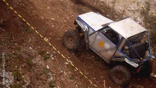 Footage of an off-road vehicle trying to drive up a hill and an uneven terrain
