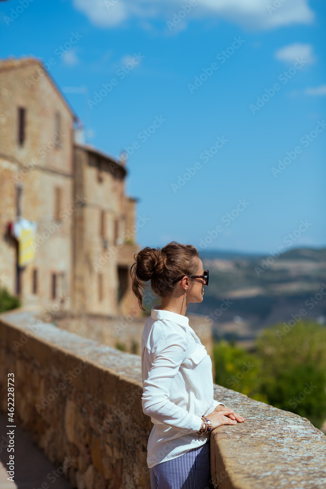 Seen from behind elegant solo tourist woman in Tuscany, Italy