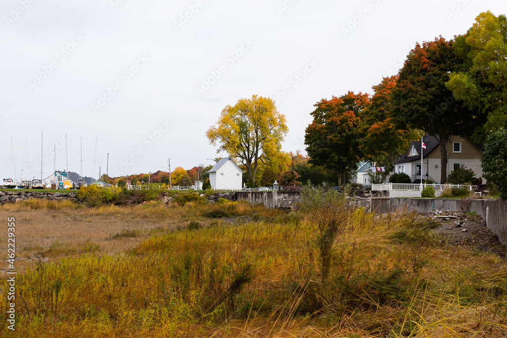 East fall view of beach, boat masts and scattering of houses in St-Michel-de-Bellechasse, Quebec, Canada