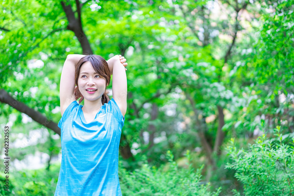 自然の中でストレッチをする若い女性 自然の中でストレッチをする若い女性