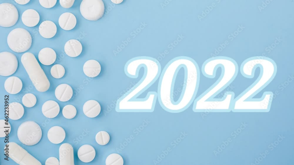 2022 Happy New Year video banner for health care and medical concept. Border made from tablets and appearing number 2022 on blue background. View from above flat lay. Medical concept christmas footage