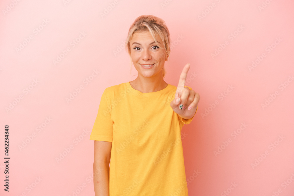 Young Russian woman isolated on pink background showing number one with finger. Young Russian woman isolated on pink background showing number one with finger.