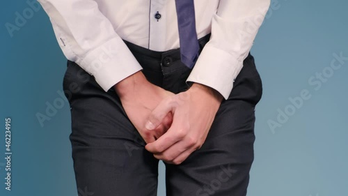 Man holding his groin with his hands feeling discomfort and pain. Concept: prostatitis, urethritis and other diseases of the urinary-reproductive system photo