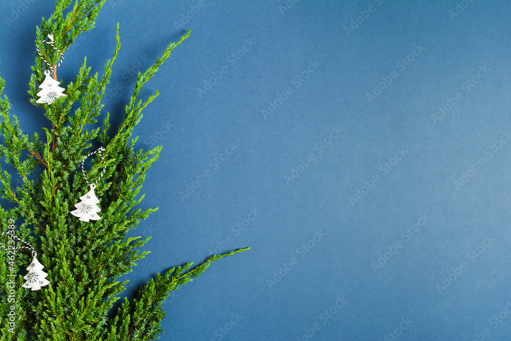 Christmas decoration on green branch of fir tree on blue background Christmas decoration on green branch of fir tree on blue background