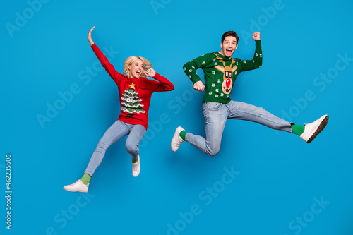 Full size photo of cool millennial couple jump wear sweater jeans socks shoes isolated on blue background