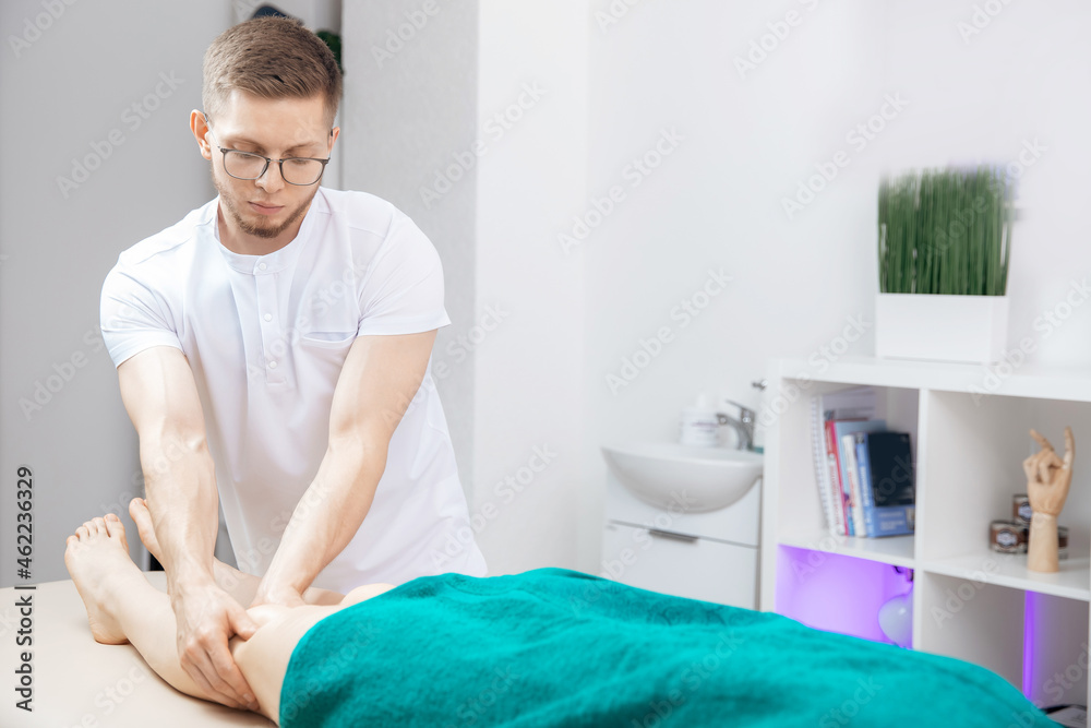 Closeup hand of therapist osteopathy working sports massage with knees legs of woman Closeup hand of therapist osteopathy working sports massage with knees legs of woman