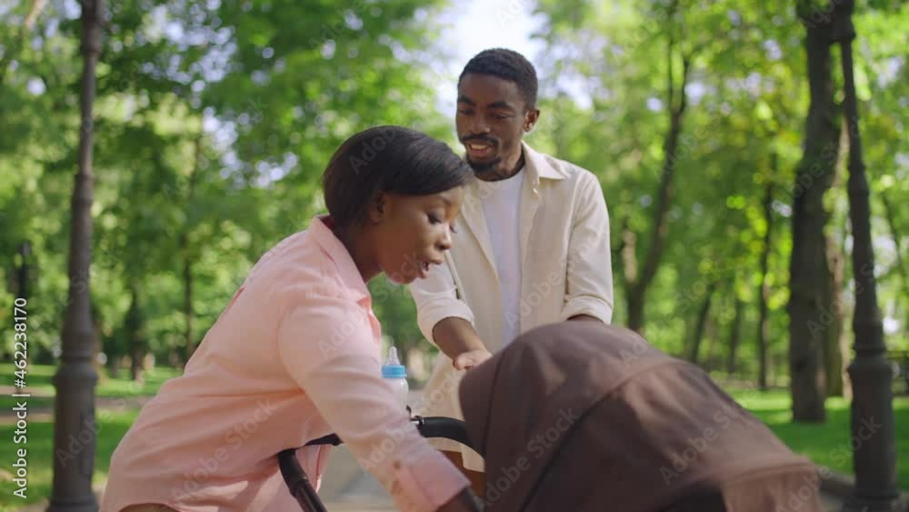 Young man arguing with wife in park, relationship stress after having baby Young man arguing with wife in park, relationship stress after having baby