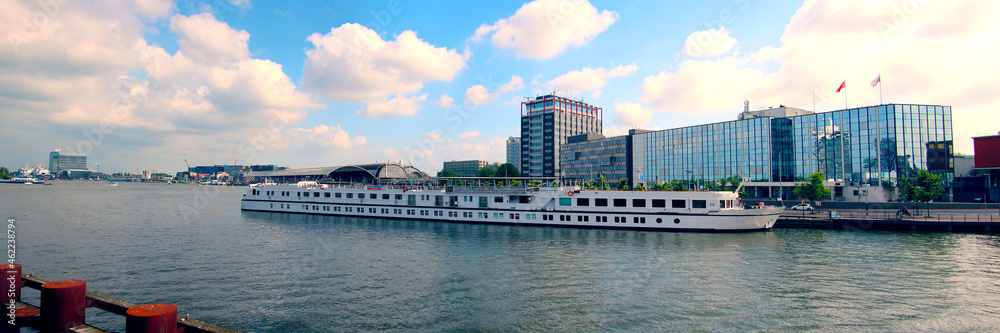 River cruise ship at dock near the main station in the city center of Amsterdam (Netherlands)