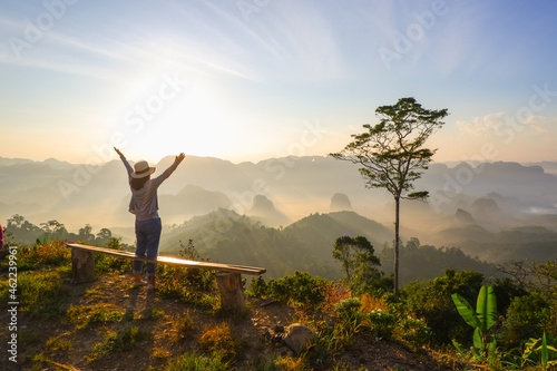 young asia woman feeling happy wearing hat resting on tropical mountain at Doi Ta Pang  khao thalu  travel in chumphon thailand