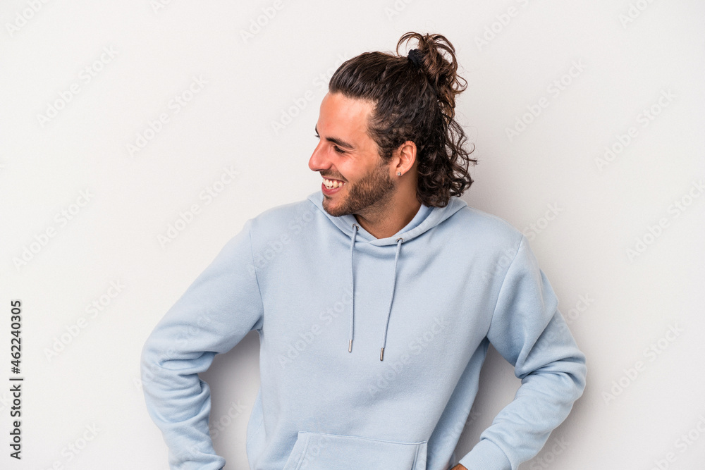 Young caucasian man isolated on gray background laughs happily and has fun keeping hands on stomach. Young caucasian man isolated on gray background laughs happily and has fun keeping hands on stomach.
