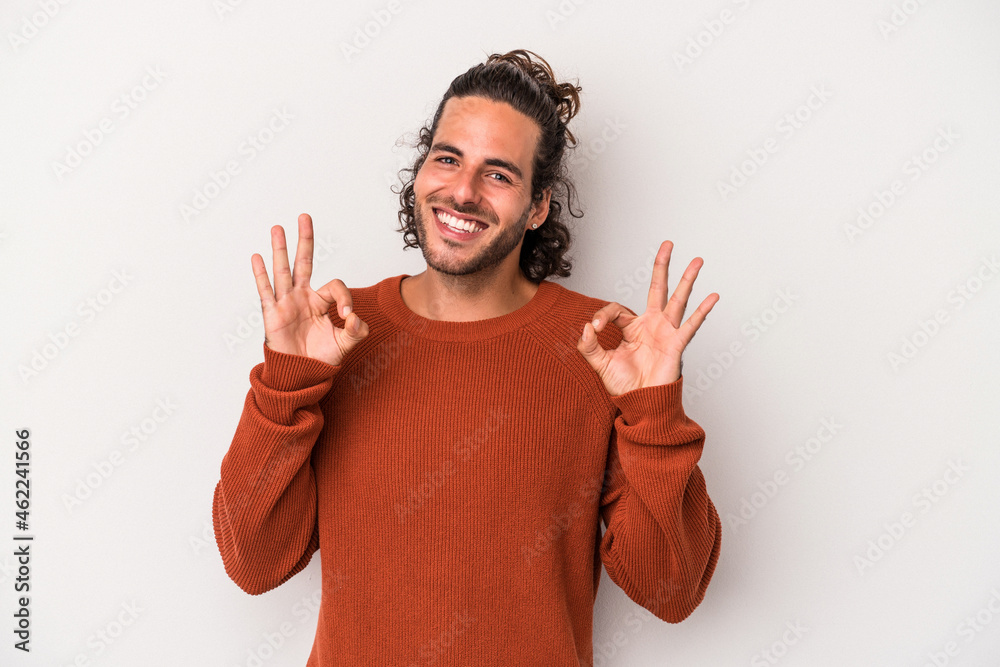 Young caucasian man isolated on gray background cheerful and confident showing ok gesture. Young caucasian man isolated on gray background cheerful and confident showing ok gesture.