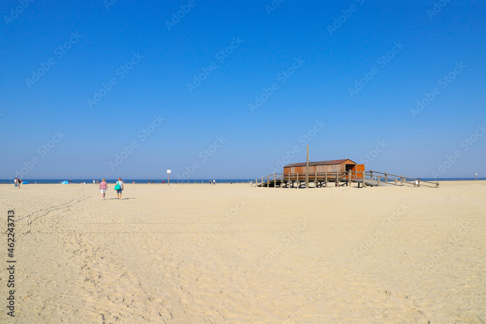 Walk and sun fun on the beach at low tide on the wide sandy beach of St. Peter Ording, North Sea - Germany