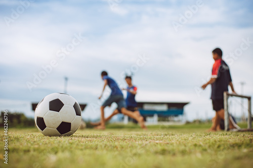 Action sport outdoors of kids having fun playing soccer football for exercise in community rural area under the twilight sunset sky. Picture with copy space