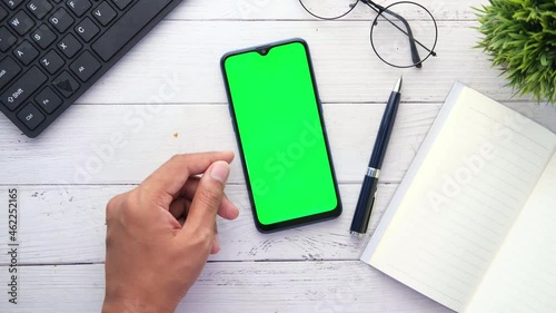 top view of man hand using smart phone on office desk  photo