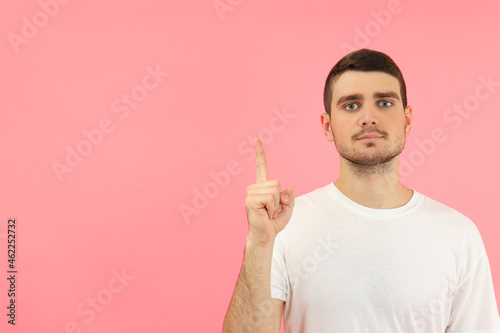 Young man with idea on pink background, space for text
