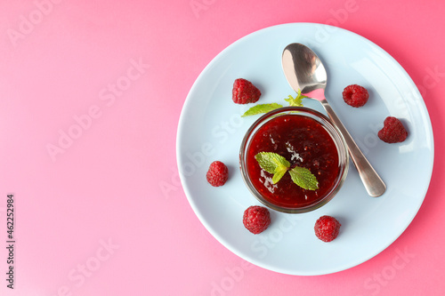 Concept of tasty food with raspberry jam on pink background