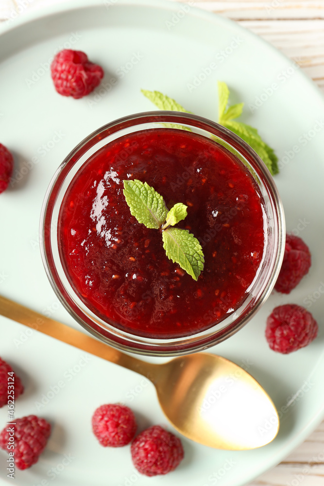 Concept of tasty food with raspberry jam on white wooden background Concept of tasty food with raspberry jam on white wooden background
