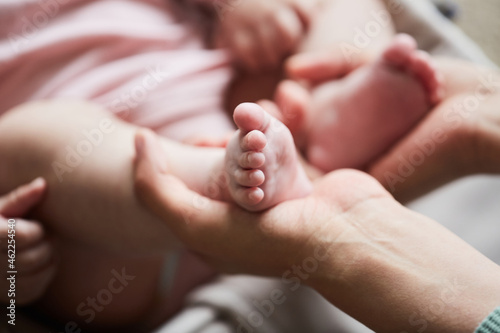 Close-up of mother holding little feet of her newborn child in her hands