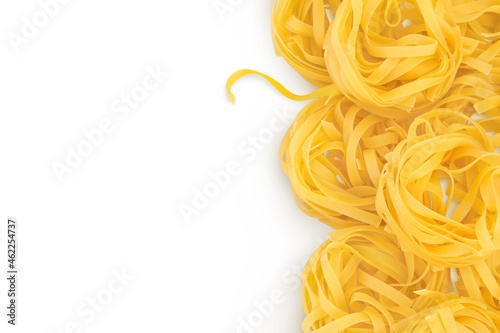 Raw tagliatelle pasta isolated on white background with clipping path and full depth of field. Top view with copy space for your text. Flat lay