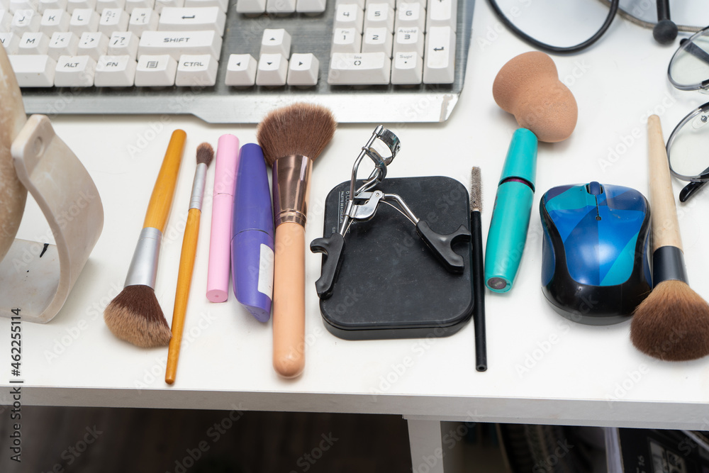 Collection of cosmetics and makeup utensils on a desk. Collection of cosmetics and makeup utensils on a desk.