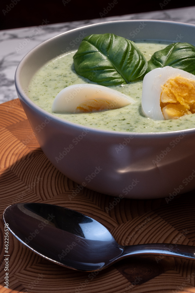 Traditional Finnish cuisines; closeup of a plate of spinach soup with boiled egg and basil topping Traditional Finnish cuisines; closeup of a plate of spinach soup with boiled egg and basil topping