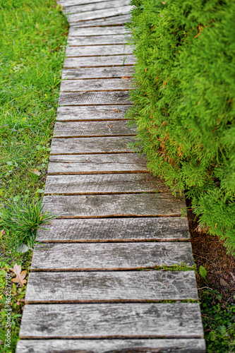 A path made of wooden planks in a garden or park. © Denis Rozhnovsky