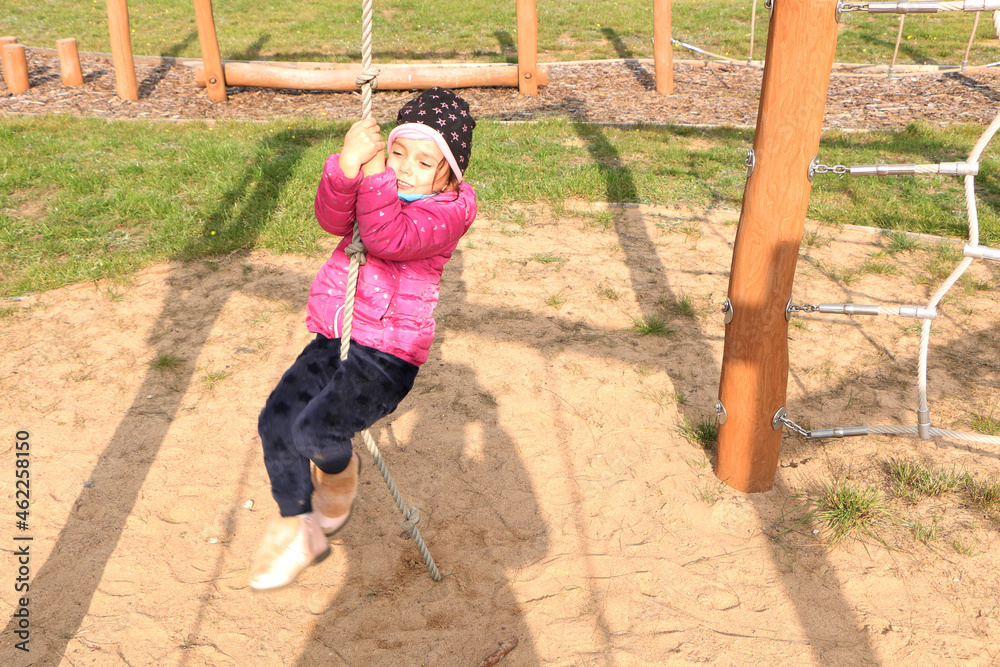 The girl plays on the playground in the fall. The girl plays on the playground in the fall.