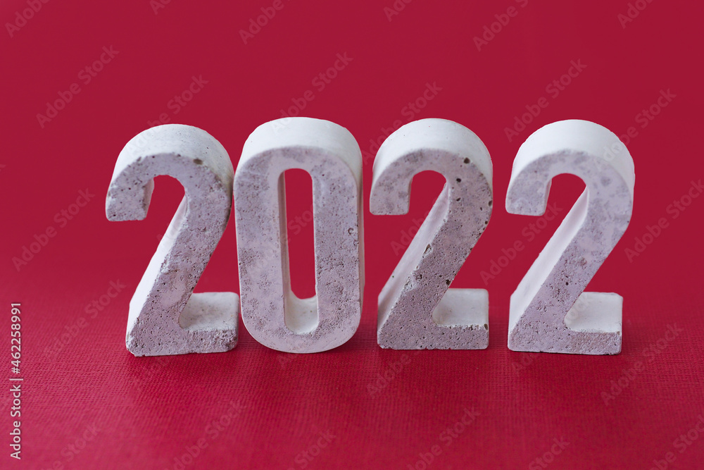 concrete numbers 2022 on burgundy background.. concrete numbers 2022 on burgundy background..
