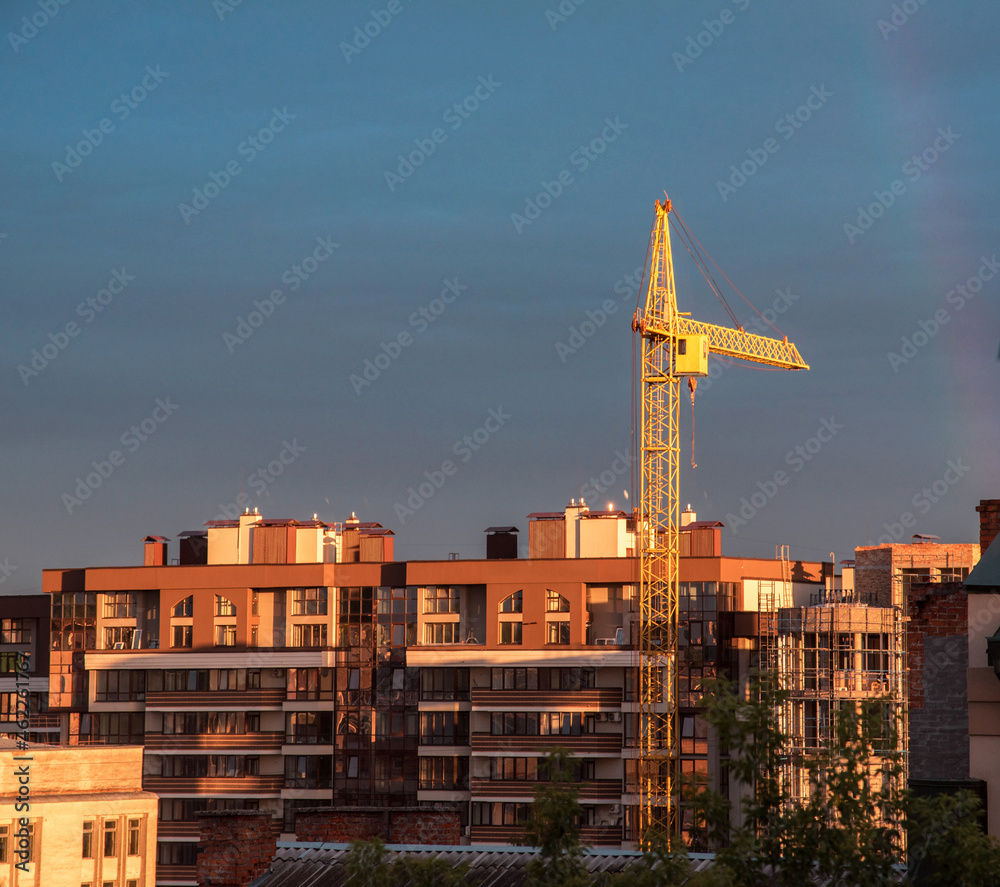 Construction crane on a background of dark sky (rising real estate prices, declining demand - concept)