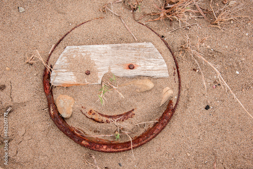 Obraz na płótnie Smile sign in the middle of the beach in the contour of rusty iron with nails instead of eyes w salonie