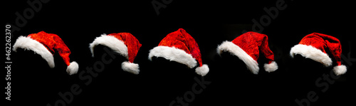 Rote Weihnachtsmützen isoliert vor schwarzem hintergrund