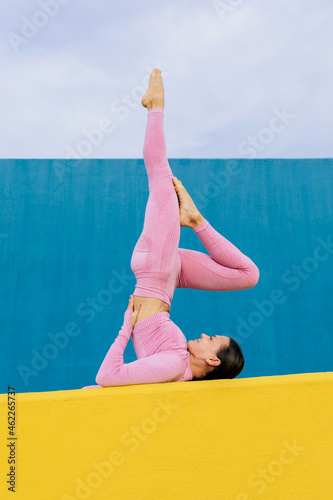 Fit woman exercising on yellow mat photo