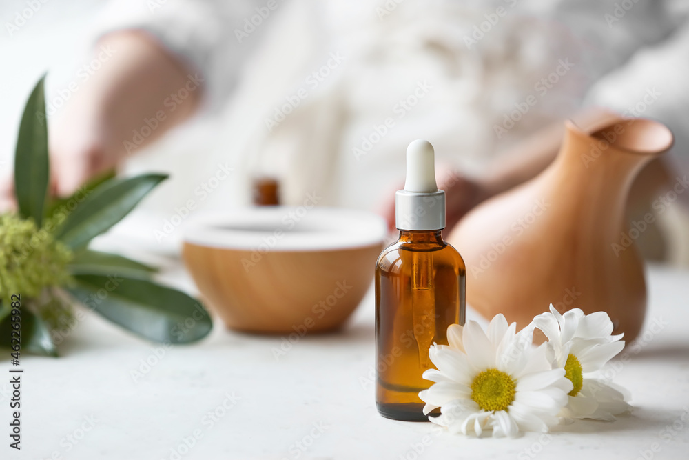 Bottle of chamomile essential oil on table Bottle of chamomile essential oil on table