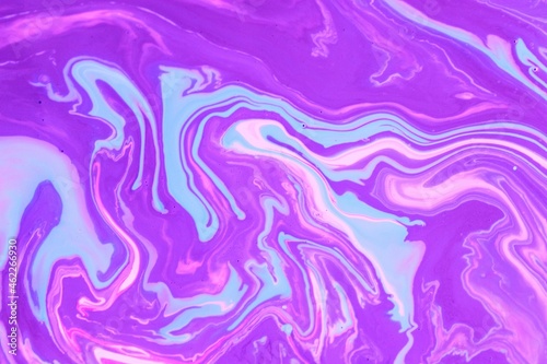 Abstract background of blue-pink marble. Acrylic paint mixes freely and creates an interesting pattern. Bright saturated shades. Background for the cover of a laptop  laptop.