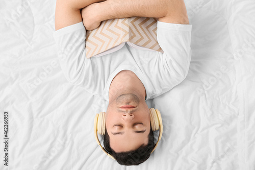 Young man with book listeni...