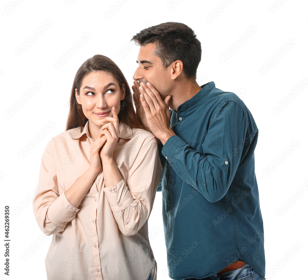 Young man sharing gossip with his girlfriend on white background Young man sharing gossip with his girlfriend on white background