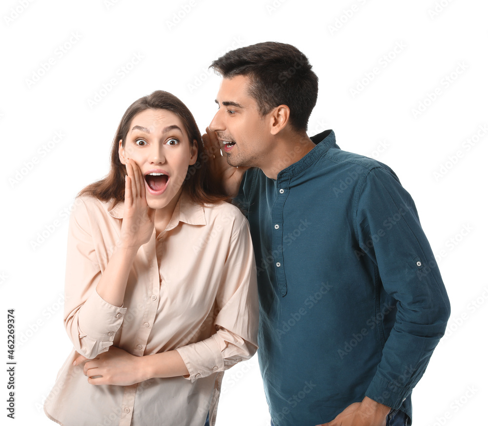 Young man sharing gossip with his girlfriend on white background Young man sharing gossip with his girlfriend on white background