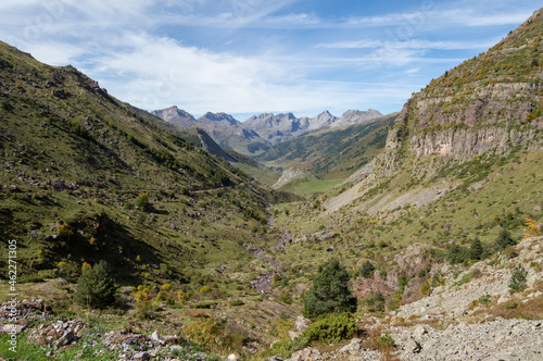 Paisaje de alta montaña pirenaico en el Valle de Hecho donde recorren sus cristalinas aguas el río Aragón Subordán junto a extensas y verdes praderas. 
