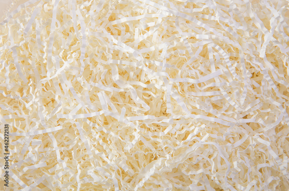 Cream color shredded paper - gift box filler background.