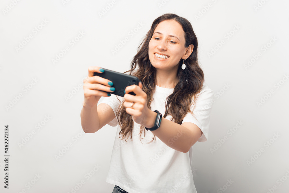 Playful young woman is playing at the phone she is holding. Playful young woman is playing at the phone she is holding.