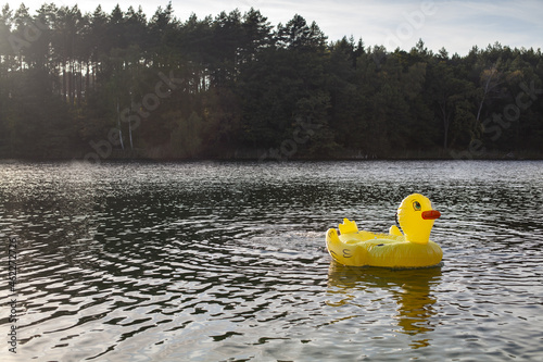 Fototapeta Naklejka Na Ścianę i Meble -  WIelka żółta dmuchana kaczka dryfująca samotnie po jeziorze