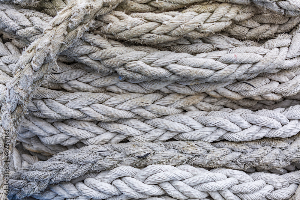 Textured surface of gray mooring rope made from natural fibers