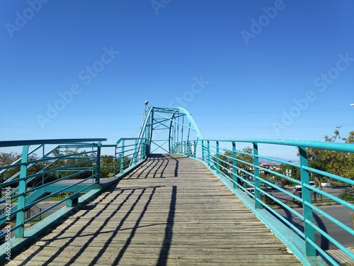  light blue painted bridge with wooden floor