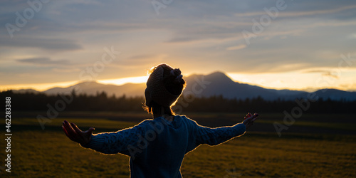 Fotografering Young woman meditating in nature at sunset
