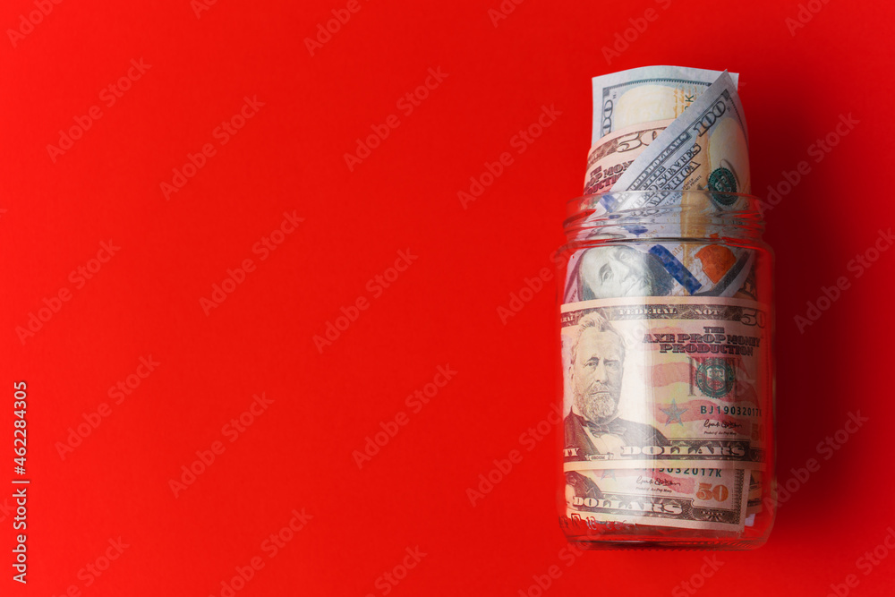 jar full of money on red background. money and savings concept. new year money saving goal.
jar full of money on red background. money and savings concept. new year money saving goal.