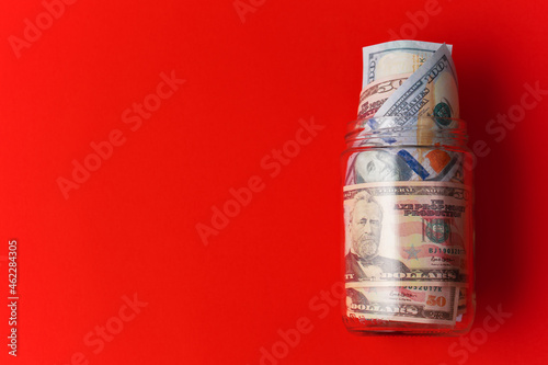 jar full of money on red background. money and savings concept. new year money saving goal. 