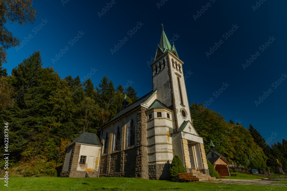 Church in Bedrichov village in autumn sunny evening with sunset light